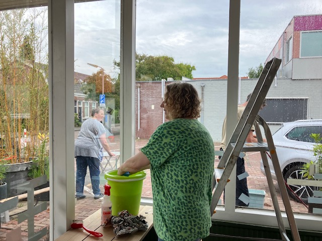 Hildy buiten en Melanie binnen aan het poetsen.